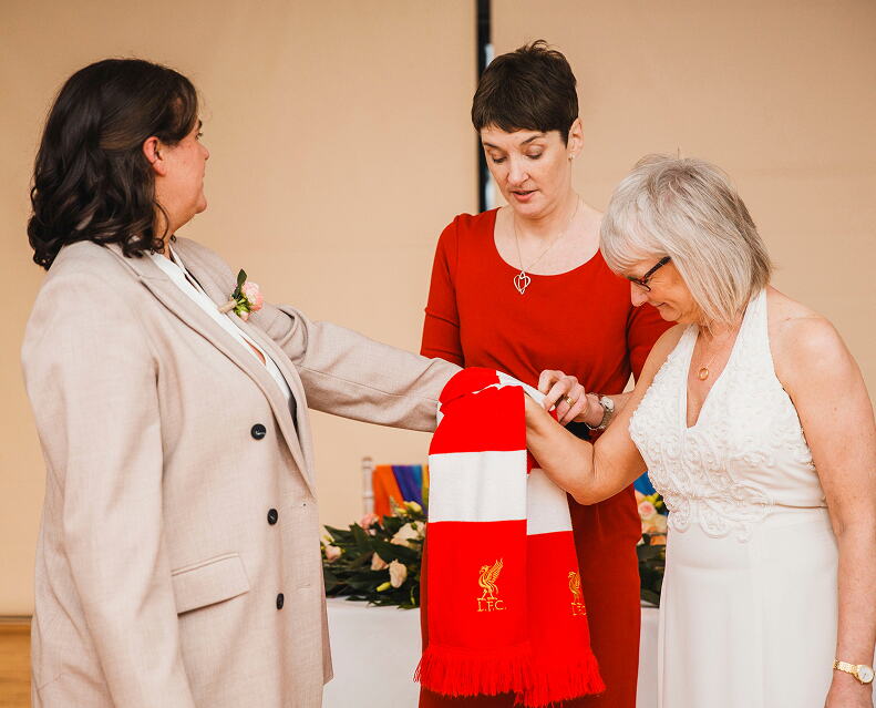 Rosemary Hartigan tying the knot for two brides with a Liverpool FC scarf during their handfasting