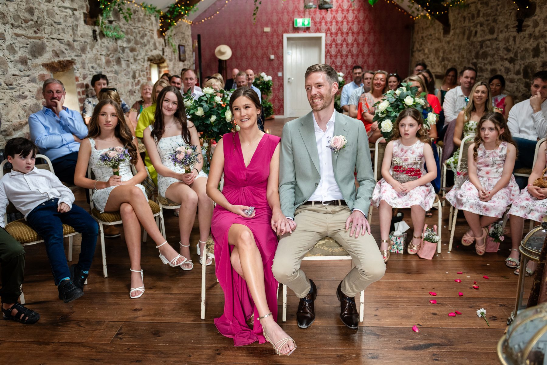 Christina and Niall smiling during their ceremony at Murphy’s Barn, Wexford, with their young bridal party beside them
