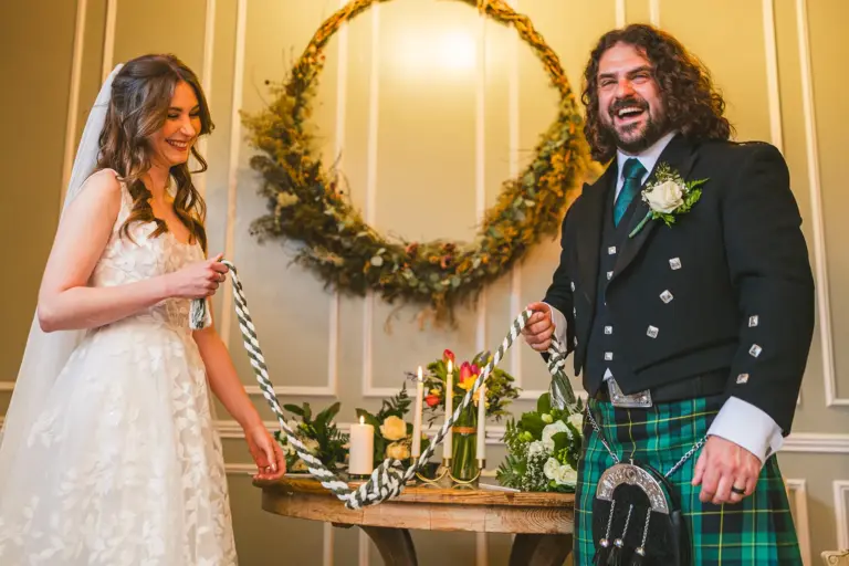 Rosemary Hartigan tying the handfasting ribbons for Ciara and Oisin at Boyne Hill House