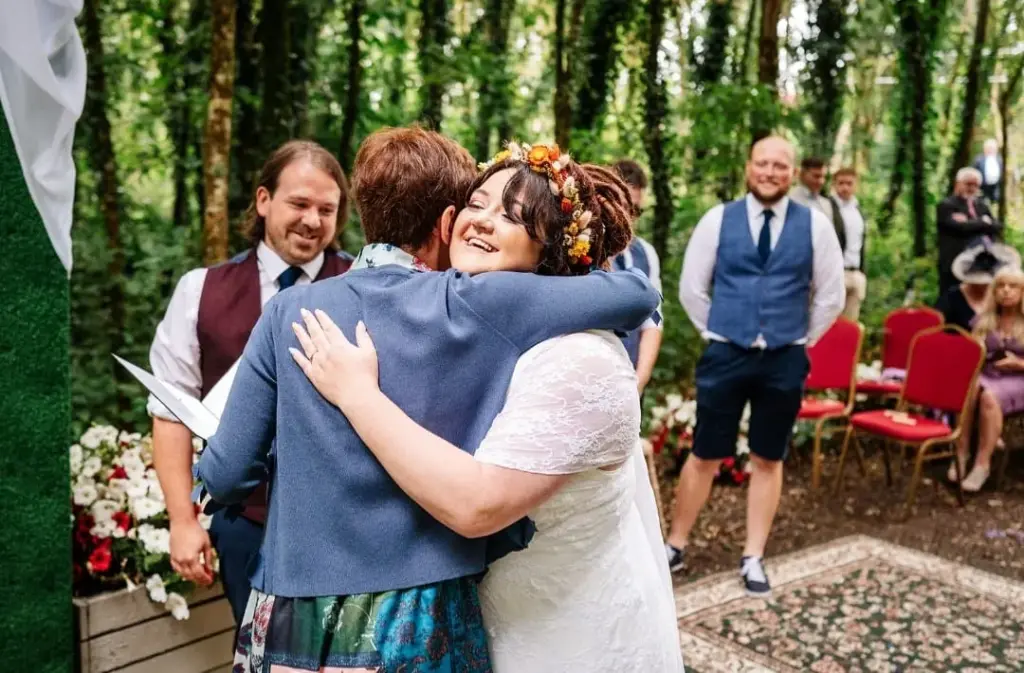 Celebrant Rosemary Hartigan embracing the bride after a woodland ceremony at the Village at Wheelocks, Wexford