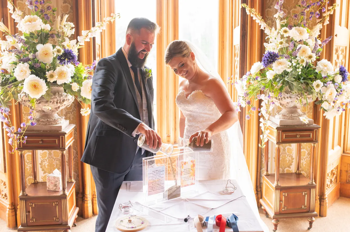 A couple pouring coloured sand during a sand blending ceremony at Johnstown Castle, Wexford